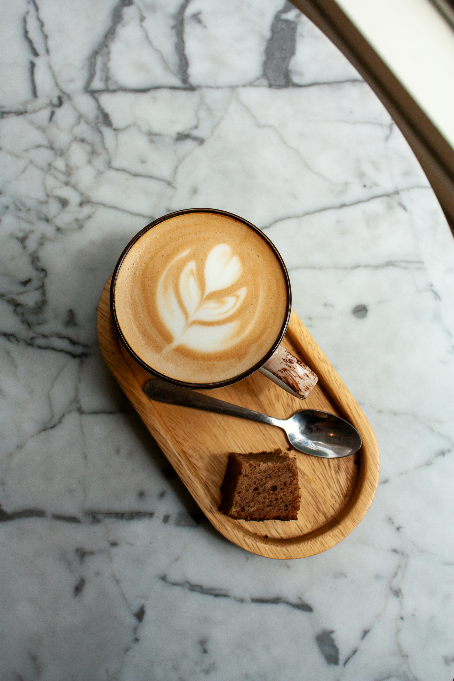 Cappuccino met latte art op marmeren tafel bij Well in Breda