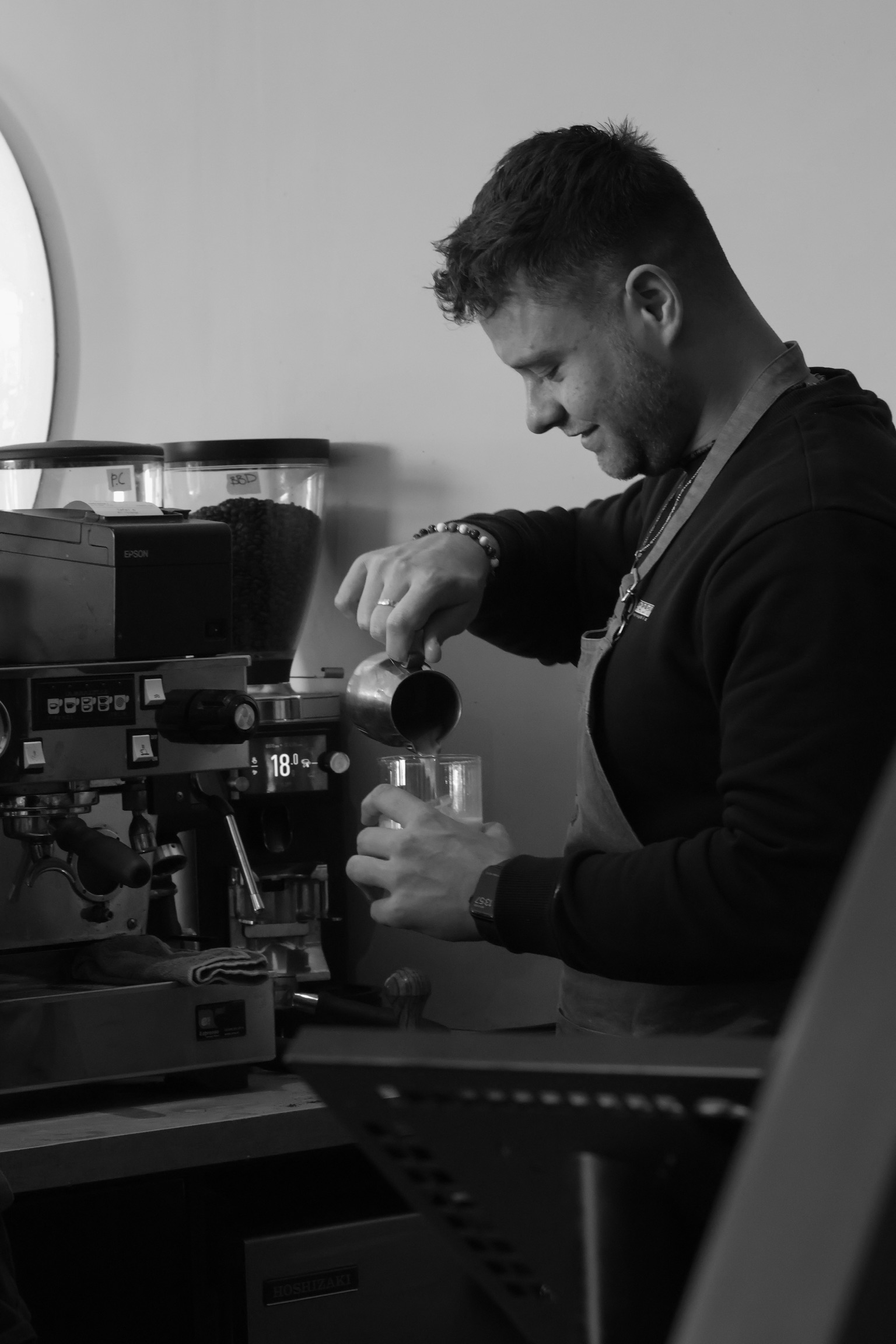 Barista schenkt melk voor specialty coffee bij Well in Breda